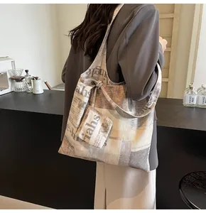 Large newspaper print canvas tote bag with matching pouch for women in a cafe setting