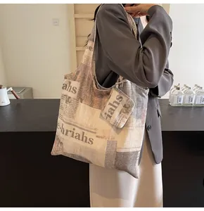Close-up of vintage newspaper print canvas tote bag with matching small pouch