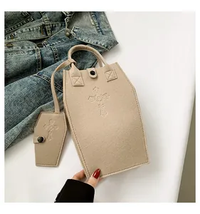 Unique coffin-shaped felt tote bag with cross embossing and matching mini sub-bag