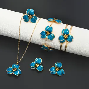 Exquisite macro shot showing the fine blue enamel and gold detailing on a floral jewelry set