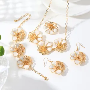 Detail view of a vintage gold floral jewelry set with white enamel petals.