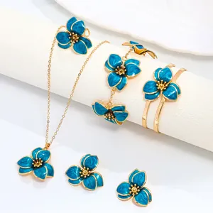 Elegant blue enamel flower jewelry set including gold necklace, bangle and earrings
