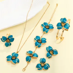 Detail view of blue enamel flower jewelry set including necklace, bracelet, and earrings