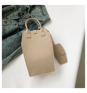 Detailed view of a minimalist beige felt tote bag set including a matching pouch charm