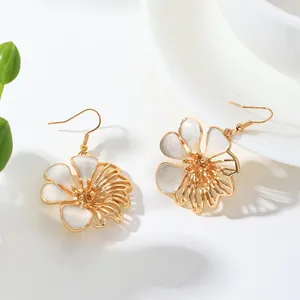 Close-up detail of vintage style flower drop earrings featuring white enamel petals.