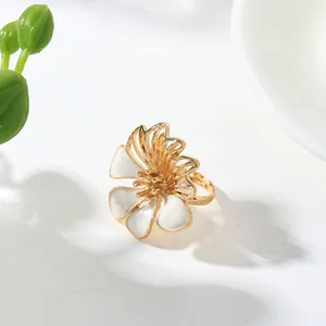 Close-up detail of a vintage floral ring featuring elegant white enamel petals in gold finish