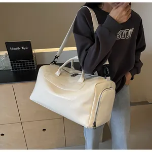 Bolsa de viaje grande en cuero sintético blanco texturizado llevada por una modelo