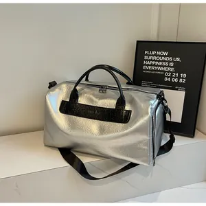 Bolsa de viaje moderna en plata metalizada con detalles de cuero negro en estilo minimalista