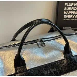 Primer plano de una bolsa de gimnasio plateada con textura metálica y doble cremallera.