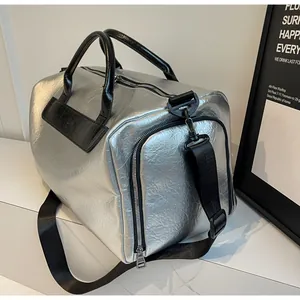 Vista detallada de la elegante bolsa de viaje metálica plateada con textura arrugada