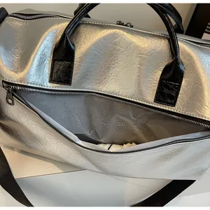 Primer plano de bolsa de viaje plateada que muestra la textura y el detalle de cremallera