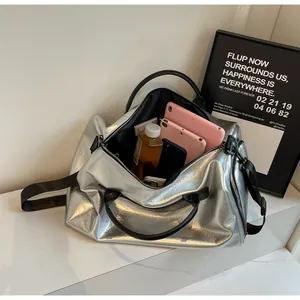 Detalle de bolsa de deporte plateada metalizada con gran capacidad interior para viajes