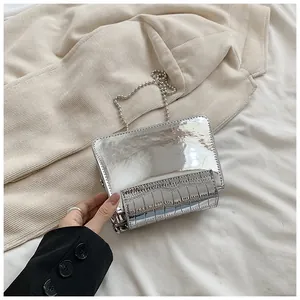 Dettaglio di borsa a tracolla argento metallizzato con texture cocco e catena a perle.