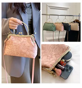 Detailweergave van vintage handtas met bloemenreliëf, strass en kusssluiting