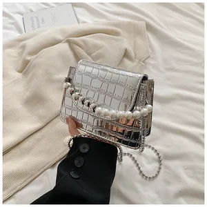 Vista dettagliata di una mini borsa quadrata argento coccodrillo con manico perle.