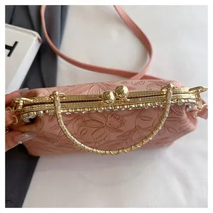 Macro-opname van roze gebloemde tas met strass sluiting en gouden ronde handgreep.