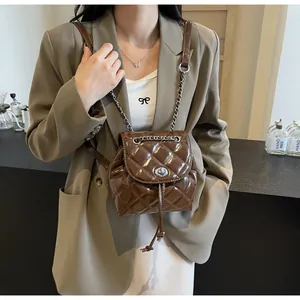 Gros plan sur la texture matelassée marron élégante et le fermoir tournant argenté du mini sac