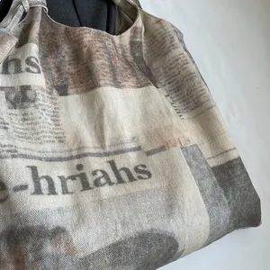 Close-up detail of a vintage newspaper print canvas tote bag texture