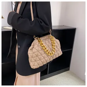 Detailansicht einer stilvollen beigefarbenen Stepptasche mit einer markanten goldenen Kette