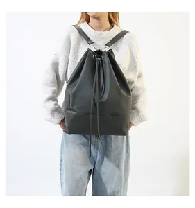 Seitenansicht eines dunkelgrauen Beutelrucksacks mit Kordelzug an einem Model