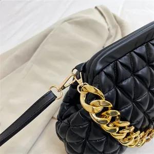 Nahaufnahme einer schwarzen Stepptasche mit einer luxuriösen goldenen Gliederkette
