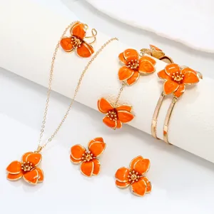Detailed view of orange enamel flower jewelry set including necklace, earrings, and bracelet