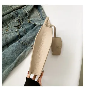 Detailed side view of a minimalist beige leather tote bag with a small matching pouch