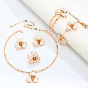 Detailed view of elegant white enamel flower jewelry set with necklace and bracelet