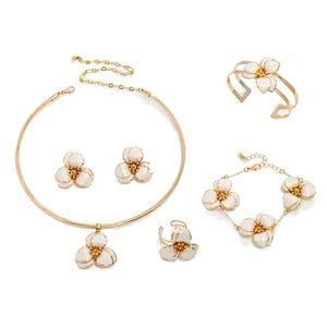 Elegant white enamel flower jewelry set with gold-tone necklace, bracelet and earrings