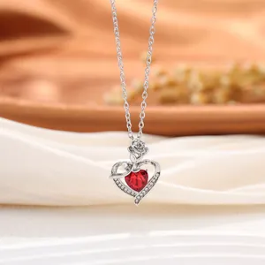 Vue détaillée du pendentif en forme de cœur argenté avec cristal rouge et rose.
