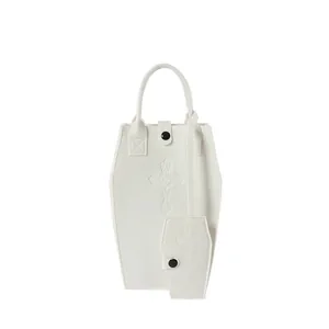 Close-up of white coffin-shaped tote bag set with embossed cross detail