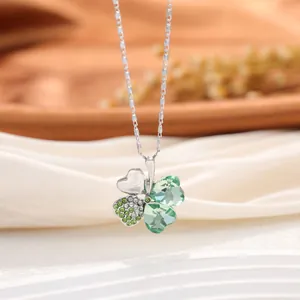 Détail du collier trèfle à quatre feuilles avec cristaux de cœur verts et chaîne argentée
