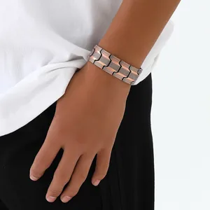 Nahaufnahme eines vintage Kupfer-Magnetarmbands mit drei Reihen an einem Männerhandgelenk.