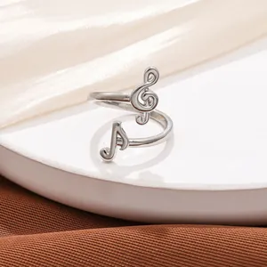 Close-up of silver adjustable music note ring with G-clef and eighth note details.