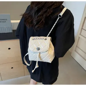 Détail du mini sac à dos blanc matelassé élégant avec des détails de chaîne en argent