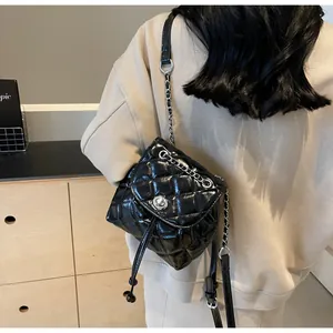 Vue arrière d'un sac seau élégant en cuir matelassé noir avec une chaîne argentée