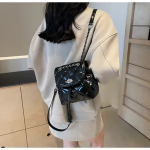 Vue arrière d'un élégant sac à dos matelassé noir avec bandoulière en chaîne argent