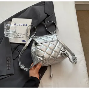Détail d'un sac à dos seau matelassé argenté avec cordon et finition métallique