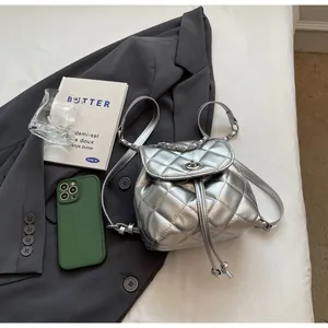 Sac à dos seau matelassé argenté tendance présenté dans une mise en scène lifestyle élégante