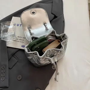 Sac seau matelassé argenté pour femme vu de dessus avec articles intérieurs visibles