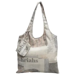 Detail of large canvas tote bag with vintage newspaper print and small matching pouch