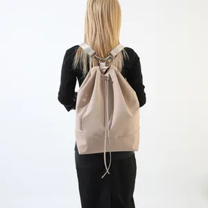 Großer beigefarbener Kordelzug-Rucksack für Sport und Reisen, am Modell gezeigt.