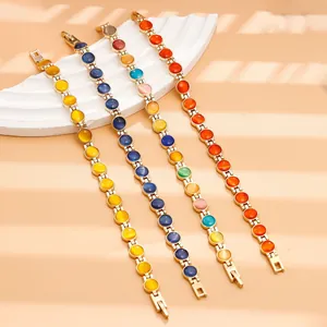 Vista dettagliata di bracciali colorati con pietre occhio di gatto e catena dorata.