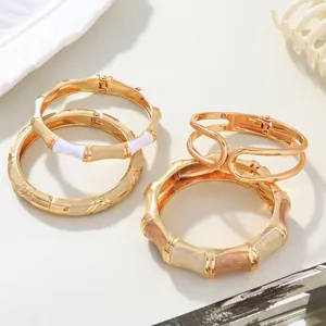 Close-up detail of fashionable gold-tone enamel bangles and bamboo-style jewelry set