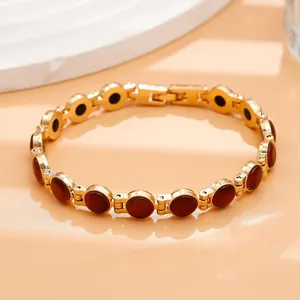 Dettaglio di un bracciale placcato oro con eleganti pietre occhio di gatto rosso scuro