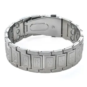 Detail view of a silver wide magnetic bracelet featuring embossed cross pattern links.
