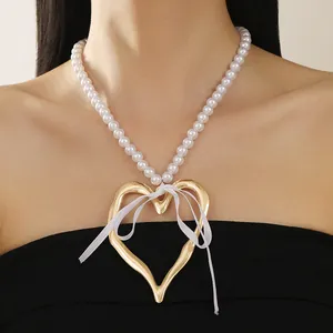 Detailed macro view of an oversized irregular gold heart pendant necklace with pearls