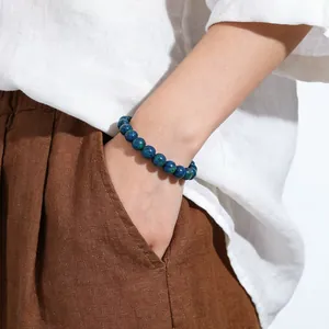 Detailed macro view of a natural blue-green stone bead bracelet worn on a person wrist