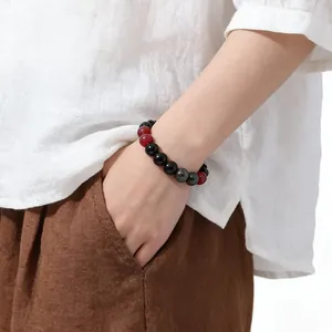 Detail shot of a beaded natural stone bracelet with black, red, and grey round beads