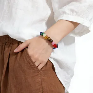 Detail view of a natural crystal beaded bracelet worn on a woman's wrist